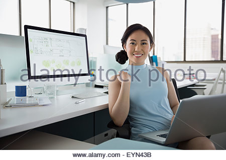 Portrait confiant architect working at laptop in office