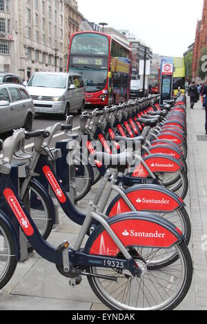 Vue D'UN RACK DE NOMBREUX SANTANDER LONDRES louer des vélos AVEC EN ARRIÈRE-PLAN LONDON BUS Banque D'Images