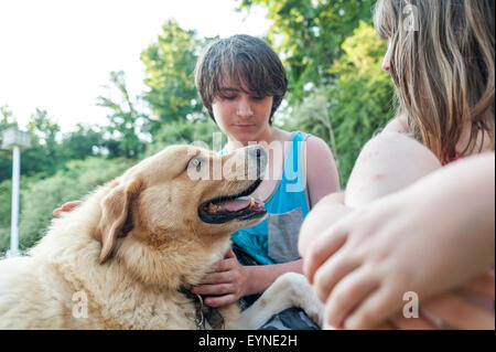 Un frère et une sœur passer du temps de qualité avec le chien de la famille. Banque D'Images