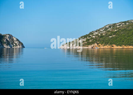 Entrée de Porto Koufo port avec petit phare et bateaux de pêche au matin, Sithonia Banque D'Images