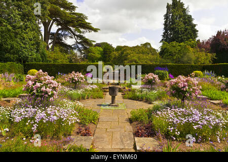 Coin tranquille d'un jardin anglais avec un drapeau vase en pierre. Banque D'Images