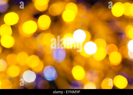 Résumé arrière-plan flou - bleu et jaune lumières de Noël scintillant de guirlandes électriques sur l'arbre de Noël Banque D'Images