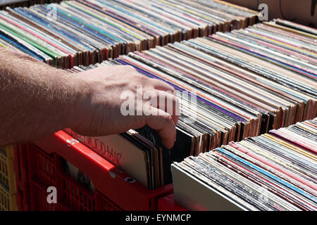 La navigation au travers de la main vintage vinyles à un marché aux puces ou vente de garage Banque D'Images