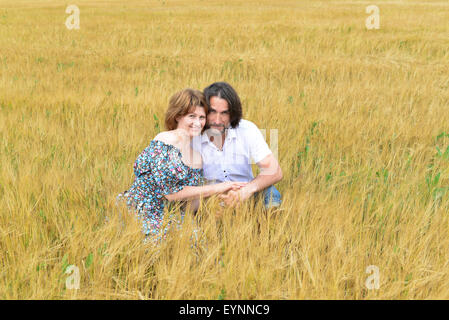 Loving couple debout dans un champ en été Banque D'Images