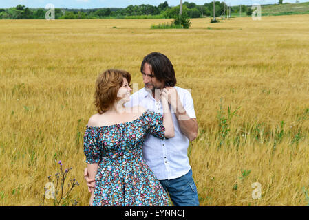 Loving couple debout dans un champ en été Banque D'Images