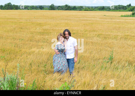 Loving couple debout dans un champ en été Banque D'Images