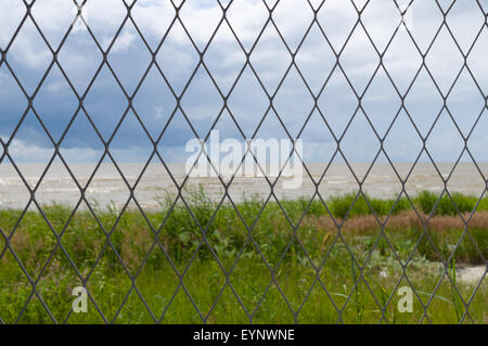 Clôture de grillage métallique contre fond mer Banque D'Images
