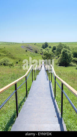 Escalier métallique avec mains courantes menant à la sainte au printemps. Grande croix orthodoxe sur une colline. Banque D'Images