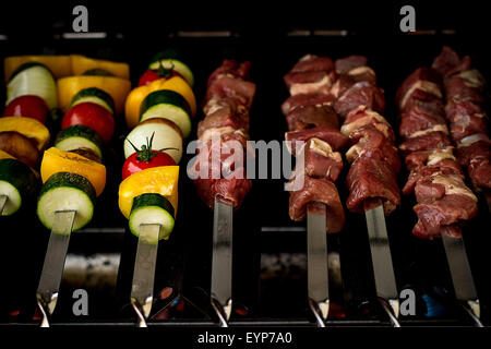 Des légumes et de la viande comme shish kebab sur grill à gaz, soft focus Banque D'Images