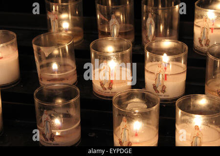 Bougies votives allumées dans l'église St Jean de Baptiste dans la ville de Saint Jean de Coles, Dordogne Banque D'Images