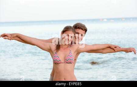 Happy young couple having fun ensemble à la plage. à l'avion