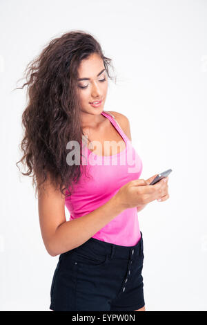 Teen girl tapant sms sur le téléphone isolé sur fond blanc Banque D'Images