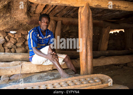 Homme Konso assis dans une maison commune ou mora dans un village Konso Konso, région, l'Ethiopie Banque D'Images