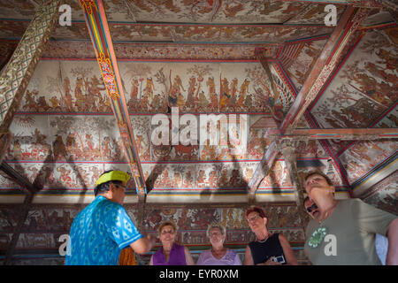Les touristes sont attentifs au plafond de l'emblématique pavillon Kertha Gosa présentant un style traditionnel balinais ancien à Klungkung, Bali. Banque D'Images