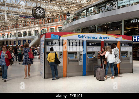 Les voyageurs en train d'acheter des billets de train à partir d'une machine en libre service sur hall de gare à Waterloo London UK Banque D'Images