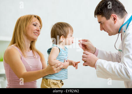 Médecin donnant une cuillère de sirop pour petit enfant Banque D'Images