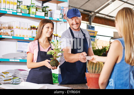 Femme de payer dans les jardins d'usine magasin d'un centre de jardin Banque D'Images