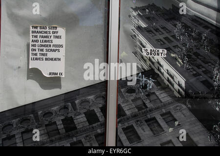 Affiche et autocollants dans la fenêtre d'un magasin désutilisé. Il fait pour une image très surréaliste. King Street East, Hamilton (Ontario). Banque D'Images