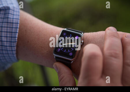 Un homme utilise un Apple Regarder Samedi 1 août 2015. Regardez Apple est une smartwatch développé par Apple qui intègre les MCARB de remise en forme Banque D'Images