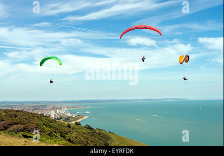 Parapente voler au-dessus de Beachy Head à Eastbourne et la jetée d''Eastbourne en arrière-plan, Eastbourne, East Sussex, UK Banque D'Images