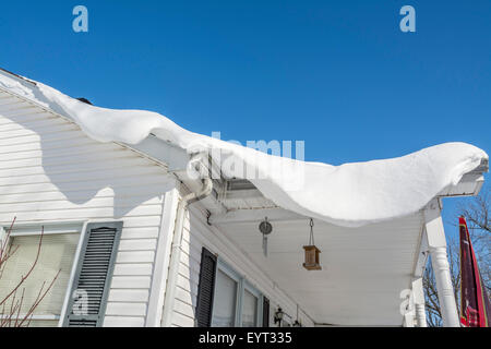 La neige profonde en surplomb de la dérive sur le toit d'une maison Banque D'Images