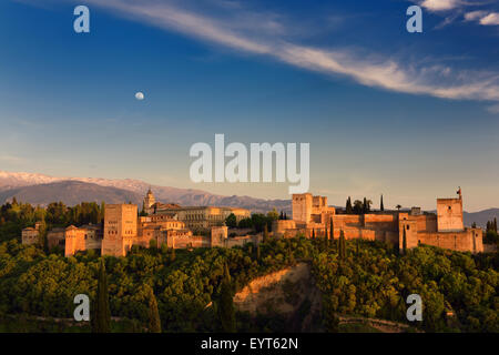 Lune et Soleil d'or sur la colline de l'Alhambra de Grenade Espagne complexe forteresse avec enneigés des montagnes de Sierra Nevada Banque D'Images