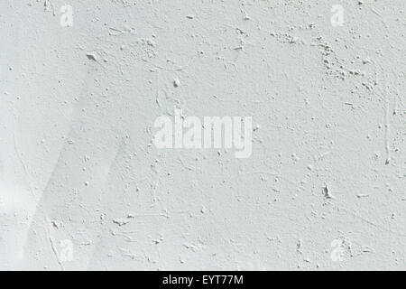 Gros plan d'un mur de béton inégal peint en blanc texture background Banque D'Images
