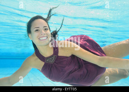 Femme, jeune, s'habiller, une piscine extérieure, d'underwaters, nager, regarder camera Banque D'Images