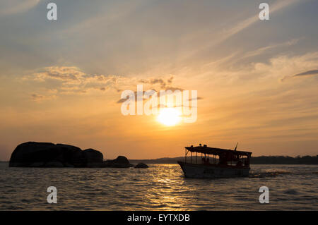 Coucher du soleil sur l'Orénoque avec la silhouette d'un petit bateau à passagers arrivant à Ciudad Bolivar. Venezuela 2015 Banque D'Images