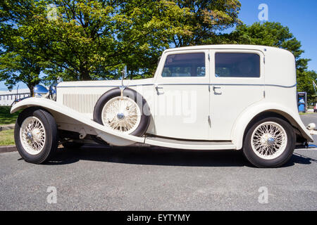 Berline de Luxe blanc Invicta, 1934 classic car, garées à l'extérieur sous ciel bleu clair. Côté passager du véhicule avec roue de secours montée sur l'aile. Banque D'Images