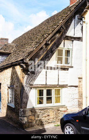 L'Angleterre, Lacock, Cotswolds. Détails architecturaux. 14e siècle pierre et bois maison Cruck, poutre en bois toit extérieur pour soutenir le toit. Banque D'Images