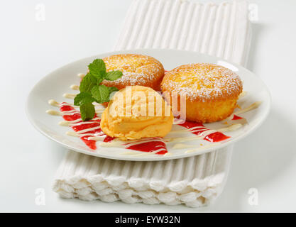 Rempli de crème anglaise muffins avec boule de glace Banque D'Images
