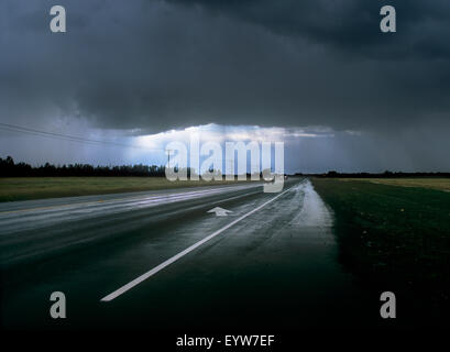 La lumière traversant les nuages sombres pendant une tempête de pluie de septembre, la Route 2, près de Athabasca, Alberta, Canada. Banque D'Images