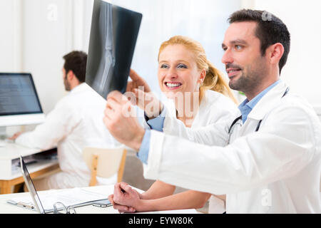 Avis d'une équipe médicale d'analyser un ensemble de rayons x à l'hôpital Banque D'Images