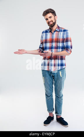 Portrait d'un homme heureux montrant le geste de bienvenue isolé sur fond blanc Banque D'Images