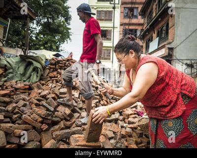 30 juillet 2015 - Katmandou, Népal - une femme recueille des briques d'argile, de recyclage et de réutilisation autour de sa maison à Katmandou qui a été détruit dans le tremblement de terre au Népal. Le tremblement de terre au Népal le 25 avril 2015, (également connu sous le nom de séisme de Gorkha) a tué plus de 9 000 personnes et blessé plus de 23 000. Il avait une magnitude de 7,8. L'épicentre était à l'est du district de Lamjung, et son hypocentre était à une profondeur d'environ 15Â km 9.3Â (mi). C'était la pire catastrophe naturelle de grève depuis le Népal 1934 Népal''"tremblement de Bihar. Le tremblement de terre a déclenché une avalanche sur le mont Everest, tuant Banque D'Images