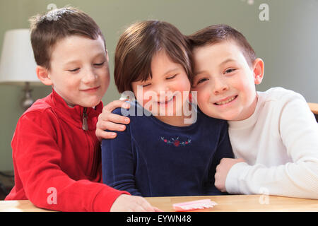 Petite fille avec le syndrome de jouer avec ses frères Banque D'Images