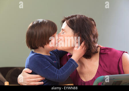 Petite fille avec le syndrome de l'embrasser maman Banque D'Images