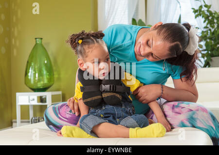 Mother holding petite fille atteinte de paralysie cérébrale Banque D'Images