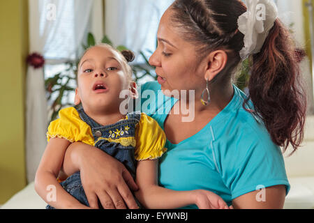 Mother holding petite fille atteinte de paralysie cérébrale Banque D'Images