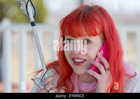 Jeune femme aveugle en conversation sur son téléphone portable Banque D'Images