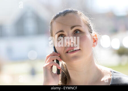 Jeune femme aveugle en conversation sur son téléphone portable Banque D'Images