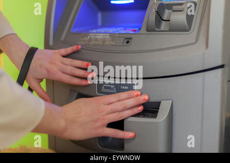 Jeune femme aveugle à l'aide d'un guichet automatique bancaire Banque D'Images