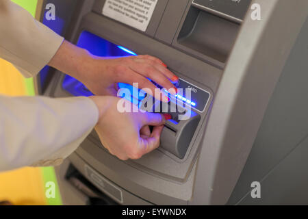 Jeune femme aveugle à l'aide d'un guichet automatique bancaire Banque D'Images