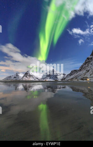 Northern Lights (aurores boréales) et les montagnes reflétée dans les eaux froides, Skagsanden, îles Lofoten, Norvège, de l'Arctique Banque D'Images