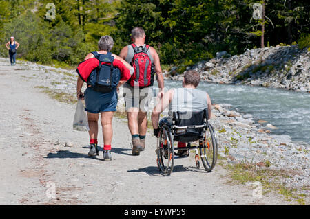 Les handicapés en fauteuil roulant de la randonnée avec des accompagnateurs de Valnontey. Parc National du Gran Paradiso. Vallée d'Aoste. Graian Alps. L'Italie. Banque D'Images