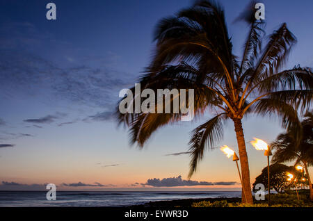 Torches Tiki au coucher du soleil sur la plage de Poipu, Kauai, Hawaï, États-Unis d'Amérique, du Pacifique Banque D'Images