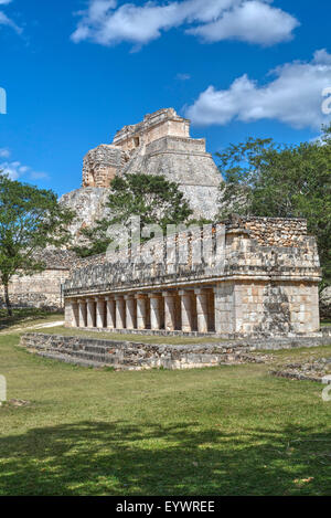 Bâtiment de colonnes en premier plan avec pyramide du magicien au-delà, Uxmal, site archéologique maya, l'UNESCO, Yucatan, Mexique Banque D'Images