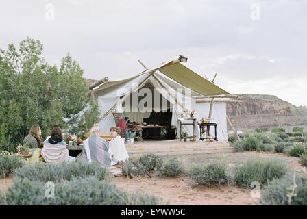 Groupe des amis des femmes bénéficiant d'un repas en plein air dans un désert d'une grande tente. Banque D'Images