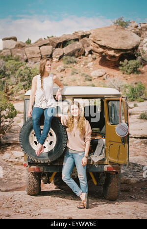 Deux femmes debout par un 4x4 sur une route de montagne. Banque D'Images